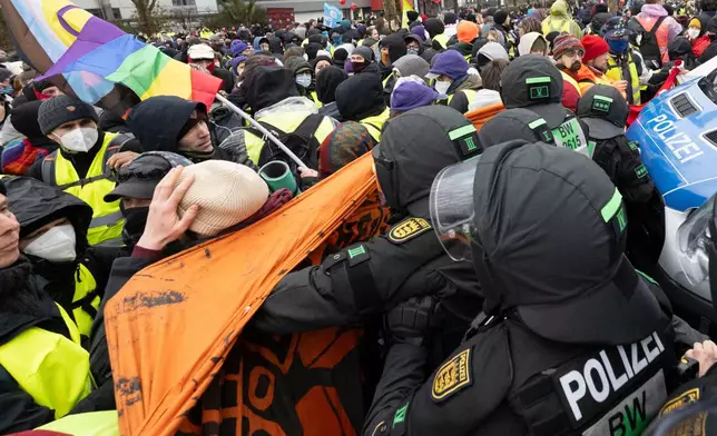 Police officers and demonstrators clash in Giessen, Germany, Saturday Nov. 29, 2025, as the far-right Alternative for Germany’s new youth organization is set to kick off its founding convention. (Boris Roessler/dpa via AP)