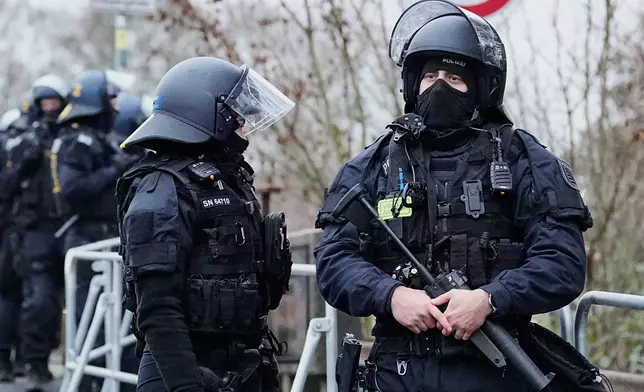 German police officers stand together during a demonstration against the planned re-founding of the AfD youth organization in Giessen, Germany, early Saturday, Nov. 29, 2025. (AP Photo/Martin Meissner)