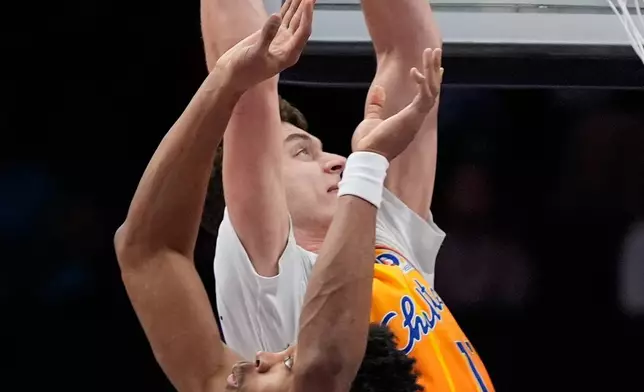 Charlotte Hornets center Ryan Kalkbrenner shoots over Toronto Raptors forward Scottie Barnes during the first half of an NBA basketball game, Saturday, Nov. 29, 2025, in Charlotte, N.C. (AP Photo/Chris Carlson)