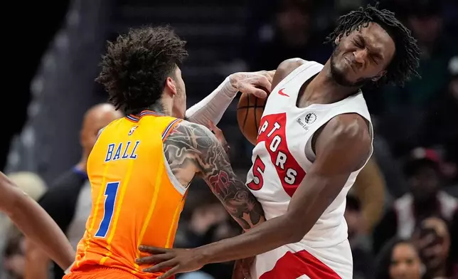 Charlotte Hornets guard LaMelo Ball collides with Toronto Raptors guard Immanuel Quickley during the first half of an NBA basketball game, Saturday, Nov. 29, 2025, in Charlotte, N.C. (AP Photo/Chris Carlson)