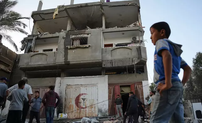 Palestinians inspect the damage to a house targeted by an Israeli strike in Deir al-Balah, in the central Gaza Strip, Saturday, Nov. 22, 2025. (AP Photo/Abdel Kareem Hana)