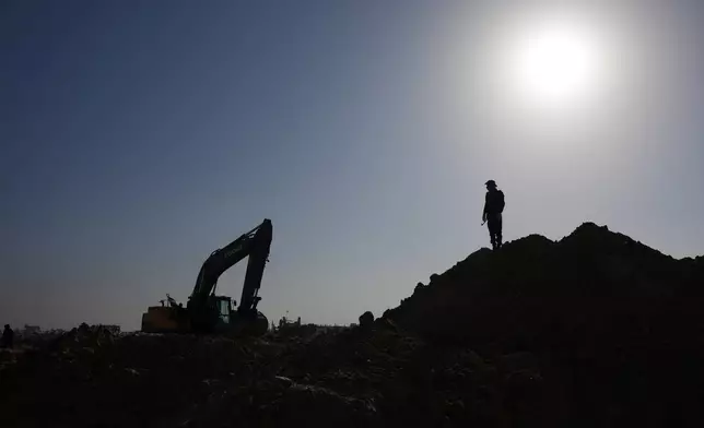Islamic Jihad militants and Egyptian workers search for the bodies of hostages north of Nuseirat, Gaza strip, Saturday, Nov. 22, 2025. (AP Photo/Abdel Kareem Hana)