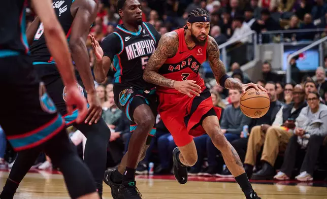 Toronto Raptors' Brandon Ingram (3) drives past Memphis Grizzlies' Vince Williams Jr. (5) during first-half NBA basketball game action in Toronto, Sunday, Nov. 2, 2025. (Sammy Kogan/The Canadian Press via AP)