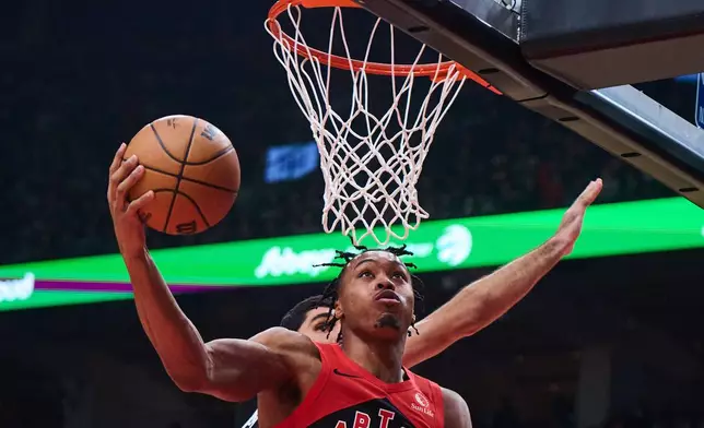 Toronto Raptors' Scottie Barnes, front, drives to the net past Memphis Grizzlies' Santi Aldama, back, during first-half NBA basketball game action in Toronto, Sunday, Nov. 2, 2025. (Sammy Kogan/The Canadian Press via AP)