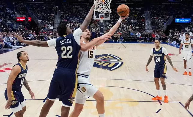 Denver Nuggets center Nikola Jokic (15) goes to the basket against New Orleans Pelicans center Derik Queen (22) in the first half of an NBA basketball game, Wednesday, Nov. 19, 2025, in New Orleans. (AP Photo/Gerald Herbert)