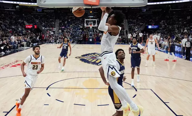 Denver Nuggets guard Peyton Watson slam dunks against the New Orleans Pelicans in the first half of an NBA basketball game, Wednesday, Nov. 19, 2025, in New Orleans. (AP Photo/Gerald Herbert)