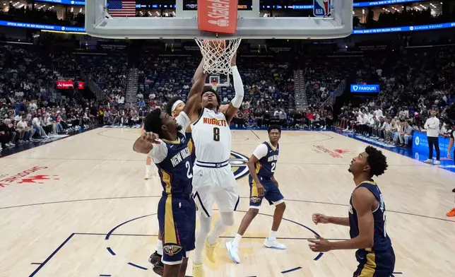 Denver Nuggets guard Peyton Watson (8) goes to the basket against New Orleans Pelicans forward Herbert Jones (2) in the first half of an NBA basketball game, Wednesday, Nov. 19, 2025, in New Orleans. (AP Photo/Gerald Herbert)