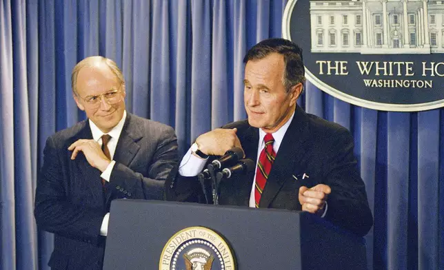 FILE - President George H.W. Bush gestures during a news conference at the White House on Friday, March 10, 1989, where he announced his selection of Rep. Richard Cheney, R-Wyo., left, to become Defense Secretary replacing his last choice of John Tower, whose nomination was turned down by the senate Thursday. (AP Photo/Charles Tasnadi, file)