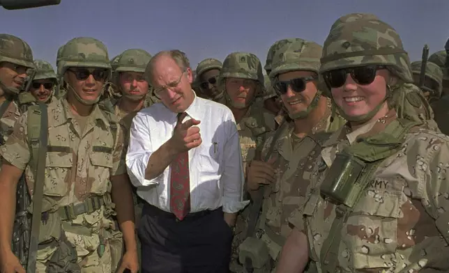 FILE - Defense Secretary Dick Cheney poses with some of the U.S. Army troops stationed in southern Iraq in this May 7, 1991 file photo. (AP Photo/Bill Haber, File)