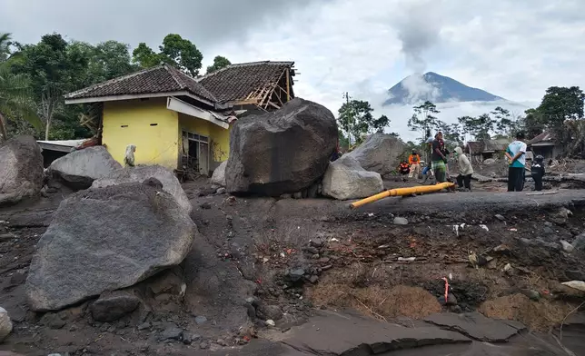 People inspect the damage caused by the eruption of Mount Semeru in Lumajang, East Java, Indonesia, Thursday, Nov. 20, 2025. (AP Photo/Wawan Sugiarto)