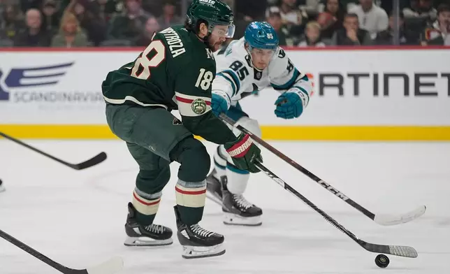 Minnesota Wild center Vinnie Hinostroza (18) skates with the puck as San Jose Sharks defenseman Shakir Mukhamadullin (85) defends during the first period of an NHL hockey game, Tuesday, Nov. 11, 2025, in St. Paul, Minn. (AP Photo/Abbie Parr)