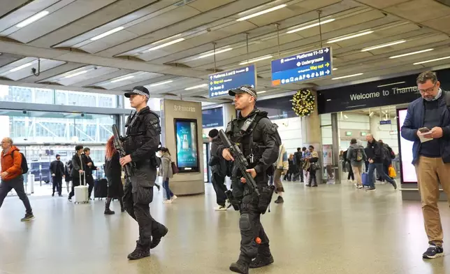 Armed police officers go on patrol at St Pancras International train station in London, England, Monday, Nov. 3, 2025. (Yui Mok/PA via AP)