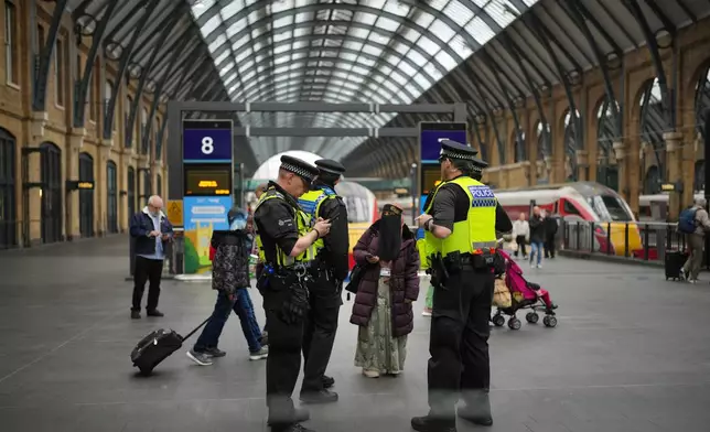 Police officers patrol King's Cross train station, in London, Monday, Nov. 3, 2025. (AP Photo/Kin Cheung)