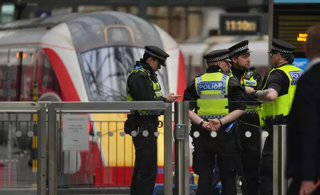 Police officers patrol King's Cross train station, in London, Monday, Nov. 3, 2025. (AP Photo/Kin Cheung)