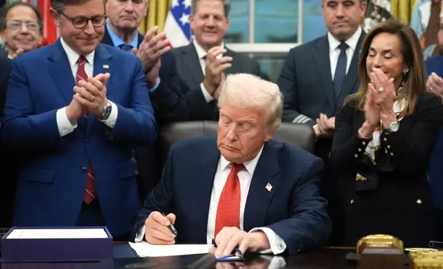 President Donald Trump signs the funding bill to reopen the government, in the Oval Office of the White House, Wednesday, Nov. 12, 2025, in Washington. (AP Photo/Jacquelyn Martin)