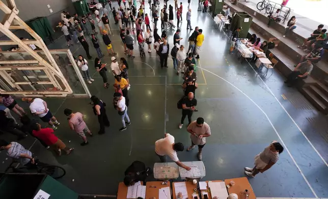 Voters line up at a polling station during general elections in Santiago, Chile, Sunday, Nov. 16, 2025. (AP Photo/Esteban Felix)