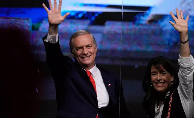Presidential candidate Jose Antonio Kast of the Republican Party, and his wife Maria Pia Adriasola, wave to supporters after early results in the general elections in Santiago, Chile, Sunday, Nov. 16, 2025. (AP Photo/Esteban Felix)