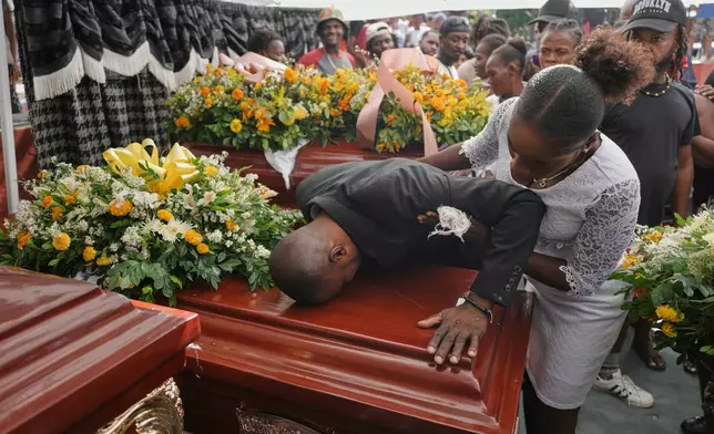 Relatives of Rosiclaire Lenchise mourn during the funeral of victims killed by a landslide triggered by Hurricane Melissa in Petit Goave, Haiti, Saturday, Nov. 15, 2025. (AP Photo/Odelyn Joseph)