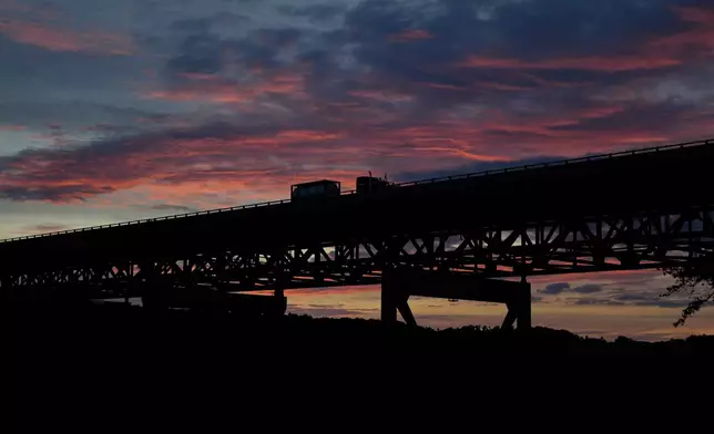 A truck drives over the New River Gorge Bridge at sunset, Sept. 16, 2025, in Victor, W.Va. (AP Photo/Carolyn Kaster)
