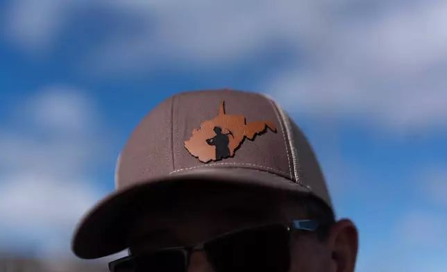 Arvin Hanshaw, of Summersville, W.Va., wears a hat with a miner silhouetted by the state of West Virginia, as he joins a group going to Washington, D.C., to protest the government's delay of the silica rule passed last year to limit exposure to deadly silica in coal mines, on Oct. 13, 2025, in Mount Hope, W.Va. (AP Photo/Carolyn Kaster)