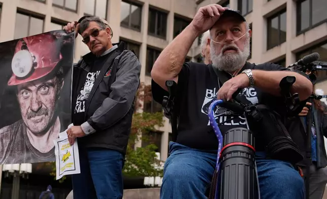 Arvin Hanshaw, of Summersville, W.Va., left, and Randy Lawrence, president of the Kanawha County Black Lung Association, right, put their hats back on after praying during a rally protesting the government's failure to limit exposure to deadly silica in mines, outside the U.S. Department of Labor, Oct. 14, 2025, in Washington. (AP Photo/Carolyn Kaster)
