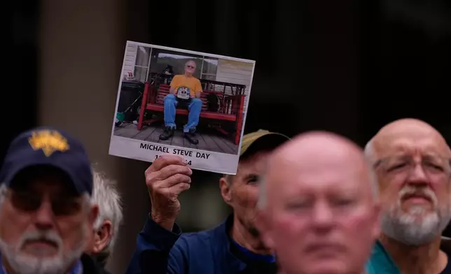 A man holds an image of Michael Steve Day Sr., a West Virginia coal miner who died of black lung disease in 2014, during a protest outside the U.S. Department of Labor, Oct. 14, 2025, in Washington. (AP Photo/Carolyn Kaster)