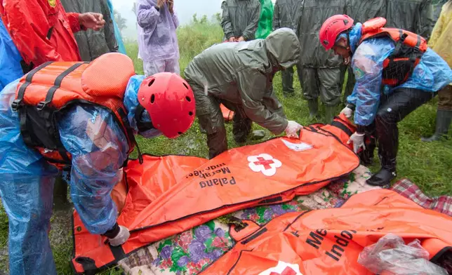 Rescuers put the bodies of flood victims in body bags, in Malalak, West Sumatra, Indonesia, Thursday, Nov. 27, 2025. (AP Photo/Ade Yuandha)