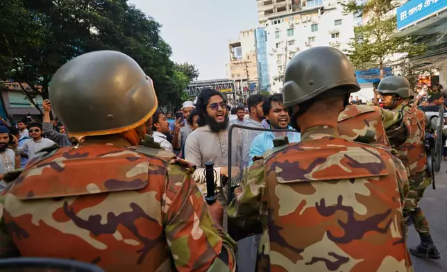 Police use baton to disperse protesters gather outside the demolished residence of Sheikh Mujibur Rahman, Bangladesh's former leader and the father of the country's ousted Prime Minister Sheikh Hasina after the verdict against Hasina, in Dhaka, Bangladesh, Monday, Nov. 17, 2025. (AP Photo/ Rajib Dhar)