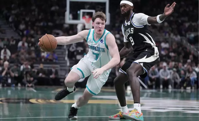 Charlotte Hornets' Kon Knueppel gets past Milwaukee Bucks' Bobby Portis during the first half of an NBA basketball game Friday, Nov. 14, 2025, in Milwaukee. (AP Photo/Morry Gash)