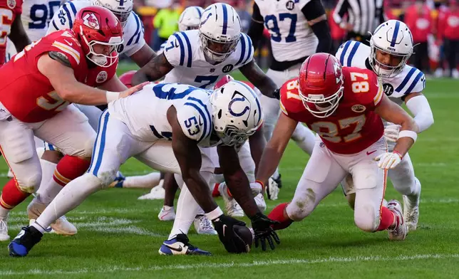 Indianapolis Colts linebacker Germaine Pratt (53) and Kansas City Chiefs tight end Travis Kelce (87) dive for a fumble during the second half of an NFL football game Sunday, Nov. 23, 2025, in Kansas City, Mo. (AP Photo/Charlie Riedel)
