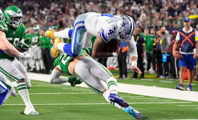 Dallas Cowboys quarterback Dak Prescott (4) leaps over Philadelphia Eagles safety Sydney Brown to score a touchdown during the second half of an NFL football game Sunday, Nov. 23, 2025, in Arlington, Texas. (AP Photo/Tony Gutierrez)