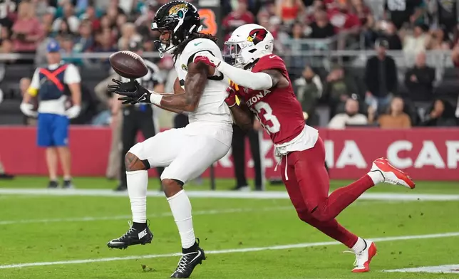 Jacksonville Jaguars wide receiver Jakobi Meyers (3) catches a pass for a touchdown against Arizona Cardinals cornerback Kei'Trel Clark (13) during the second half of an NFL football game Sunday, Nov. 23, 2025, in Glendale, Ariz. (AP Photo/Ross D. Franklin)