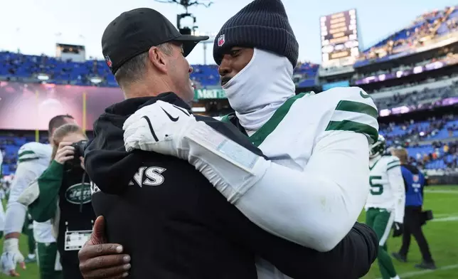 Baltimore Ravens head coach John Harbaugh, left, and New York Jets quarterback Tyrod Taylor, right, meet on the field after an NFL football game, Sunday, Nov. 23, 2025, in Baltimore. (AP Photo/Stephanie Scarbrough)