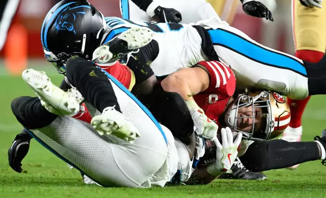 San Francisco 49ers running back Christian McCaffrey is tackled by Carolina Panthers linebacker Bam Martin-Scott and linebacker Krys Barnes during the second half an NFL football game, Monday, Nov. 24, 2025, in Santa Clara, Calif. (AP Photo/Eakin Howard)
