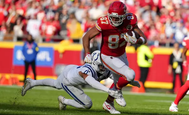 Kansas City Chiefs tight end Travis Kelce (87) is tackled by Indianapolis Colts safety Camryn Bynum (0) during the first half of an NFL football game Sunday, Nov. 23, 2025, in Kansas City, Mo. (AP Photo/Ed Zurga)