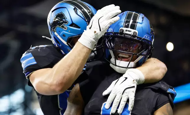 Detroit Lions running back Jahmyr Gibbs, right, is congratulated by a teammate after his touchdown catch against the New York Giants during the first half of an NFL football game in Detroit, Sunday, Nov. 23, 2025. (AP Photo/Rey Del Rio)