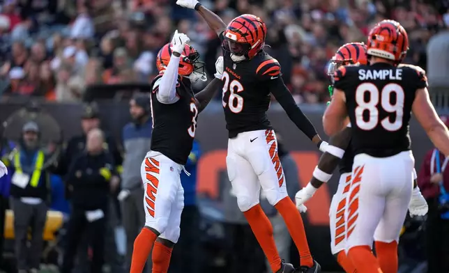 Cincinnati Bengals safety Tycen Anderson (26) celebrates with teammate PJ Jules, left, after making a tackle during the first half of an NFL football game against the New England Patriots, Sunday, Nov. 23, 2025, in Cincinnati. (AP Photo/Carolyn Kaster)