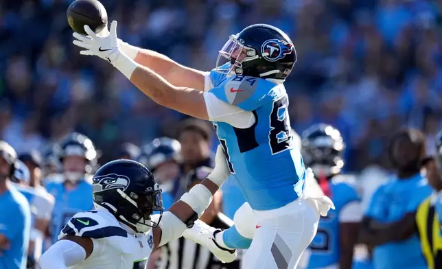 Seattle Seahawks linebacker Uchenna Nwosu (7) breaks up a pass intended for Tennessee Titans tight end Gunnar Helm (84) during the first half of an NFL football game Sunday, Nov. 23, 2025, in Nashville, Tenn. (AP Photo/George Walker IV)
