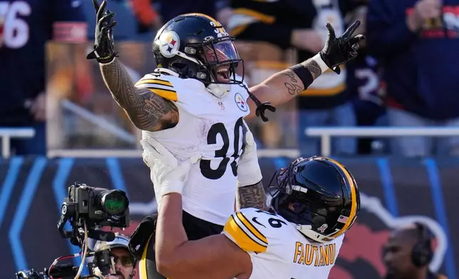 Pittsburgh Steelers running back Jaylen Warren (30) celebrates his touchdown with Troy Fautanu during the first half of an NFL football game against the Chicago Bears, Sunday, Nov. 23, 2025, in Chicago. (AP Photo/Erin Hooley)