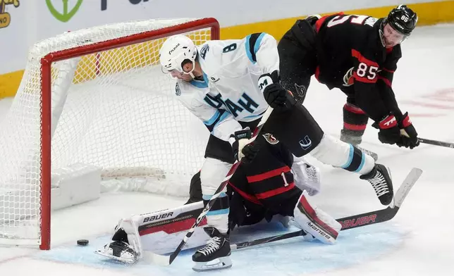 Ottawa Senators defenceman Jake Sanderson (85) looks on as Utah Mammoth centre Nick Schmaltz (8) scores on goaltender Leevi Merilainen (1) during second period NHL action, in Ottawa, Sunday, Nov. 9, 2025. (Adrian Wyld/The Canadian Press via AP)