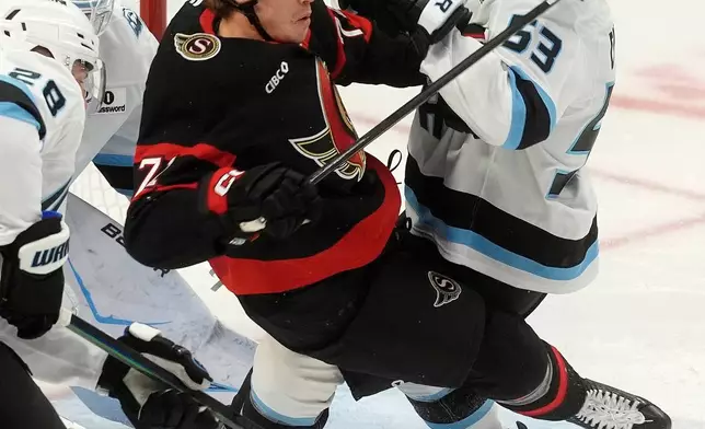 Ottawa Senators centre Ridly Greig (71) collides with Utah Mammoth left wing Michael Carcone (53) in front of the net during first period NHL action, in Ottawa, Sunday, Nov. 9, 2025. (Adrian Wyld/The Canadian Press via AP)