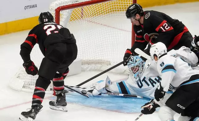 Ottawa Senators right wing Claude Giroux (28) and center Shane Pinto (12) try and put the puck past Utah Mammoth goaltender Vitek Vanecek, bottom left, during third-period NHL hockey game action in Ottawa, Ontario, Sunday, Nov. 9, 2025. (Adrian Wyld/The Canadian Press via AP)