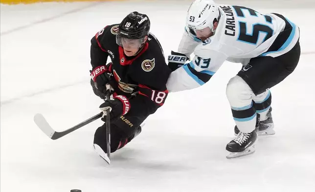 Utah Mammoth left wing Michael Carcone (53) brings down tOttawa Senators centre Tim Stutzle (18) during third period NHL action, in Ottawa, Sunday, Nov. 9, 2025. (Adrian Wyld/The Canadian Press via AP)