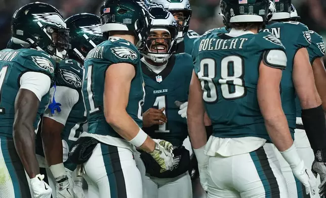 Philadelphia Eagles quarterback Jalen Hurts (1) talks with teammates during the first half of an NFL football game against the Detroit Lions on Sunday, Nov. 16, 2025, in Philadelphia. (AP Photo/Matt Rourke)