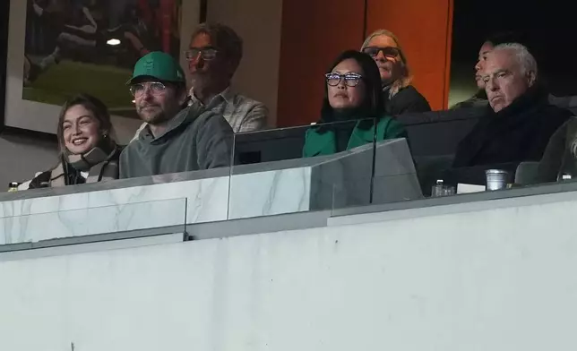 Gigi Hadid, left, sits in a box with Bradley Cooper, second from left, and Philadelphia Eagles owner Jeffrey Lurie, right, during the first half of an NFL football game between the Philadelphia Eagles and the Detroit Lions on Sunday, Nov. 16, 2025, in Philadelphia. (AP Photo/Matt Slocum)