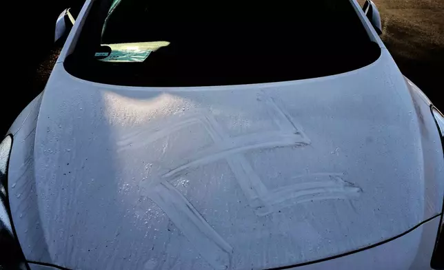 The remains of a swastika are seen on a car in Hanau, Germany, Thursday, Nov. 6, 2025, the day after a a person painted with blood swastikas on cars and houses. (AP Photo/Michael Probst)
