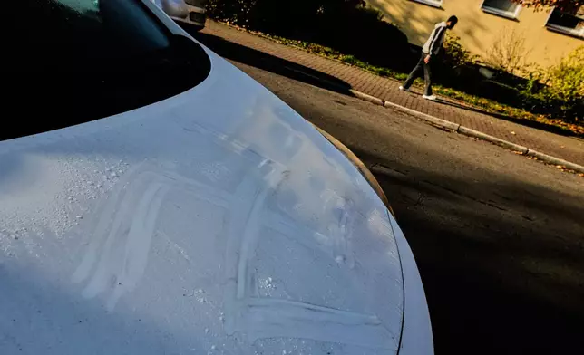 The remains of a swastika are seen on a car in Hanau, Germany, Thursday, Nov. 6, 2025, the day after a a person painted with blood swastikas on cars and houses. (AP Photo/Michael Probst)