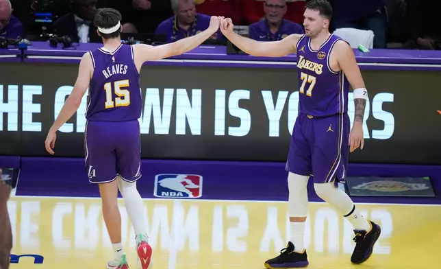 Los Angeles Lakers guard Luka Doncic (77) celebrates his basket with guard Austin Reaves (15) during the first half of an NBA Cup basketball game against the Los Angeles Clippers Tuesday, Nov. 25, 2025, in Los Angeles. (AP Photo/Jae C. Hong)