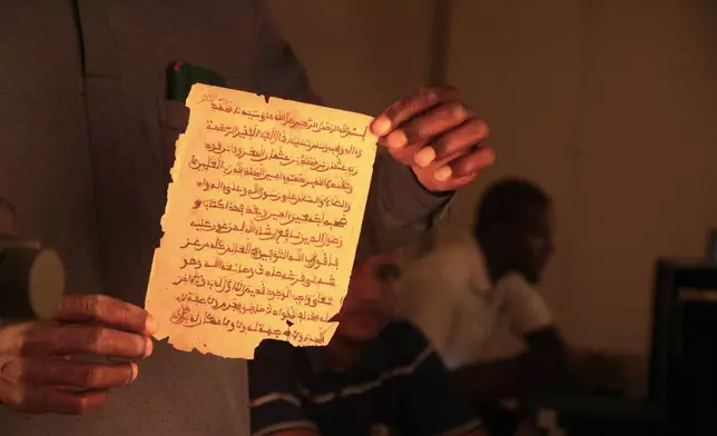 An employee displays a manuscript at the Ahmed Baba Institute of Higher Islamic Studies and Research in Timbuktu, Mali, Sept. 4, 2025. (AP Photo/Baba Ahmed)