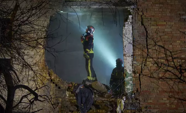 Rescuers search for victims after a drone hit a residential building during Russia's night missile and drone attack in Kyiv, Ukraine, Saturday. Nov. 29, 2025. (AP Photo/Efrem Lukatsky)